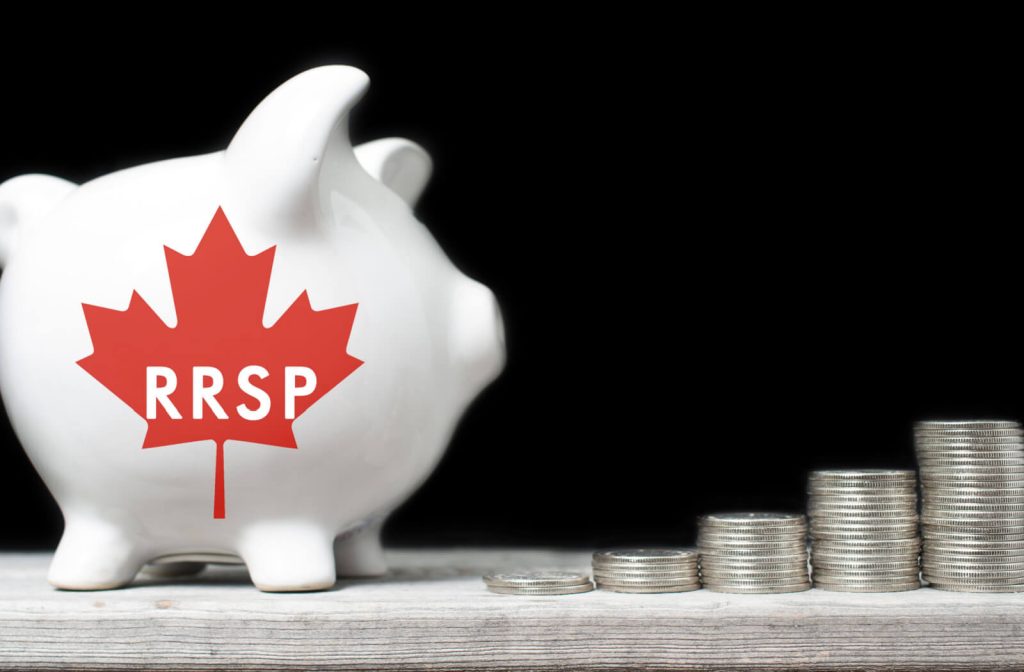 A ceramic piggy bank with "RRSP" written on it in a maple leaf sits on a wooden shelf with coins stacked in the background.