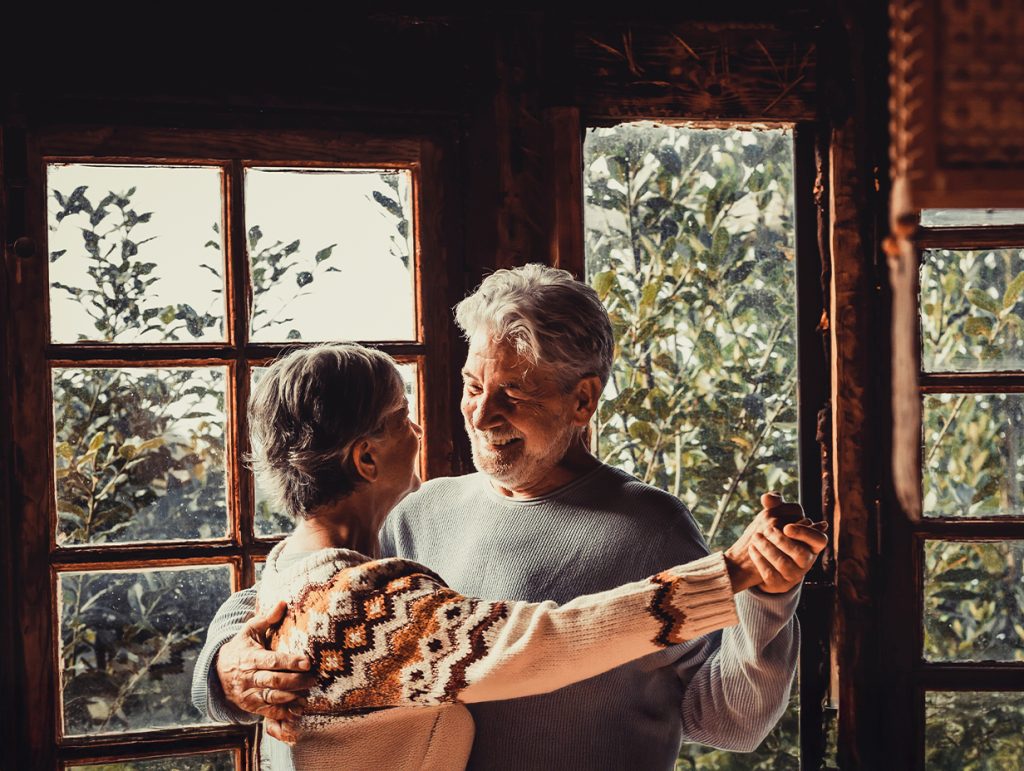 A mature couple smiling while they dance