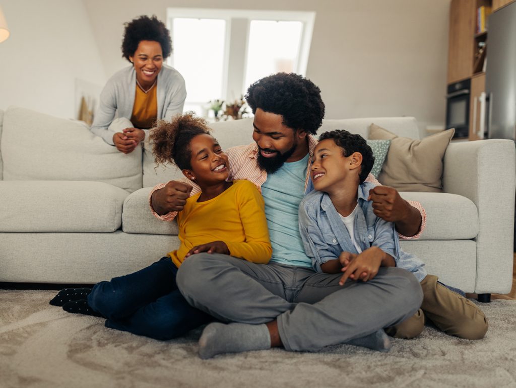 A young family laughing in their home