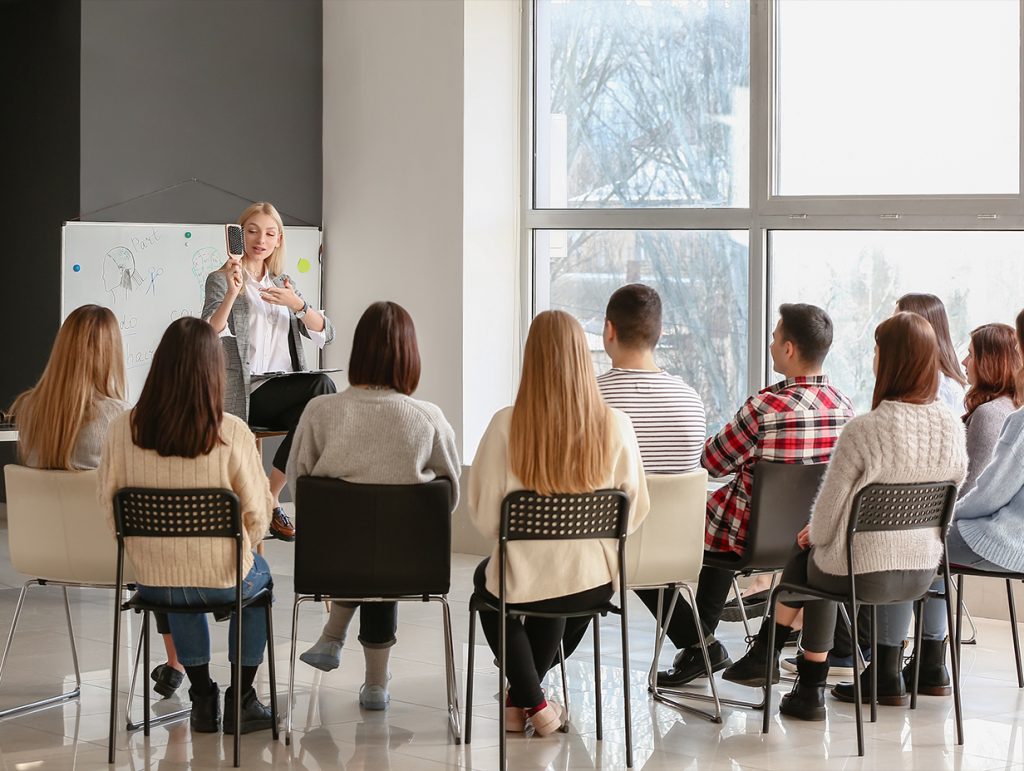 A team of professionals sitting and learning from a work trainer