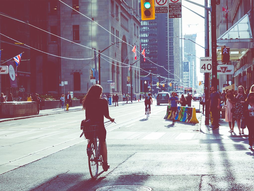 Woman riding her bike in the sunrise in the big city
