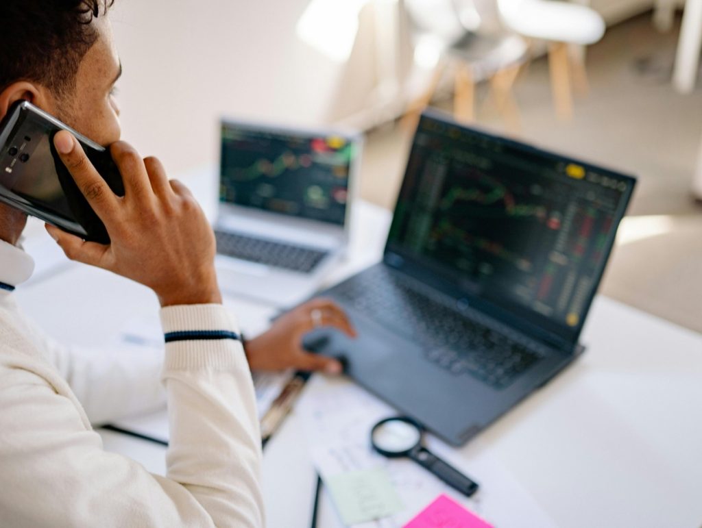 day trader reading his data on two separate laptops