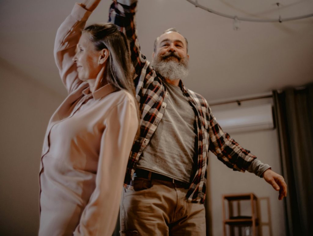 elderly couple dancing in their living room