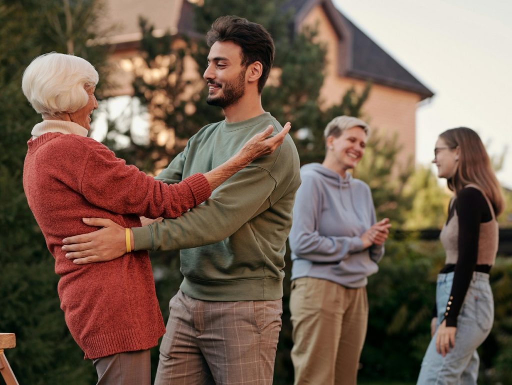 grandson and grandmother hugging at a family barbeque