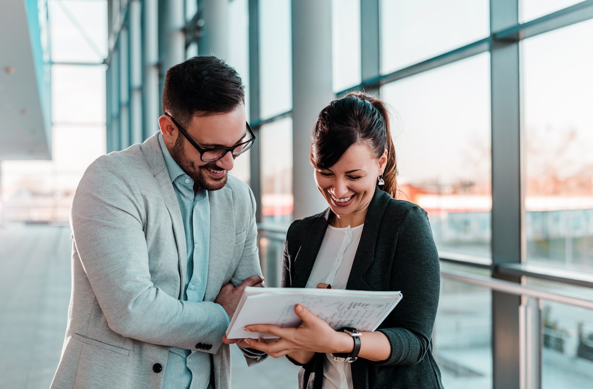 woman showing man a document of all the fees he is paying to his financial advisor