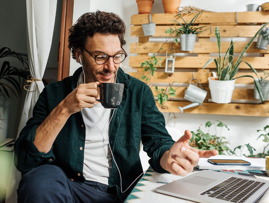 man reviewing his finances while drinking a coffee and listening to music