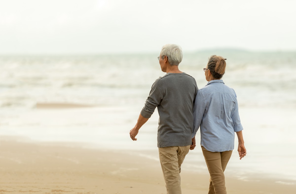 retired couple walking on the beach