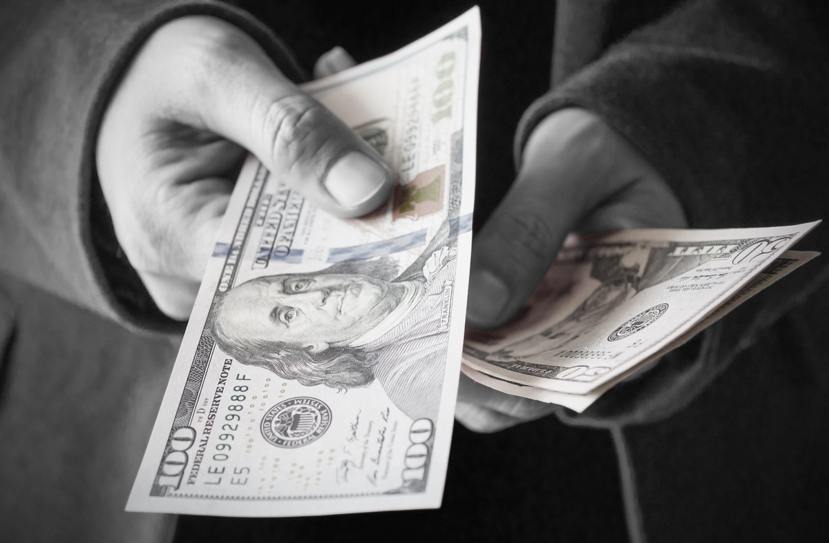 Man giving money from his wallet person counting and handing out money