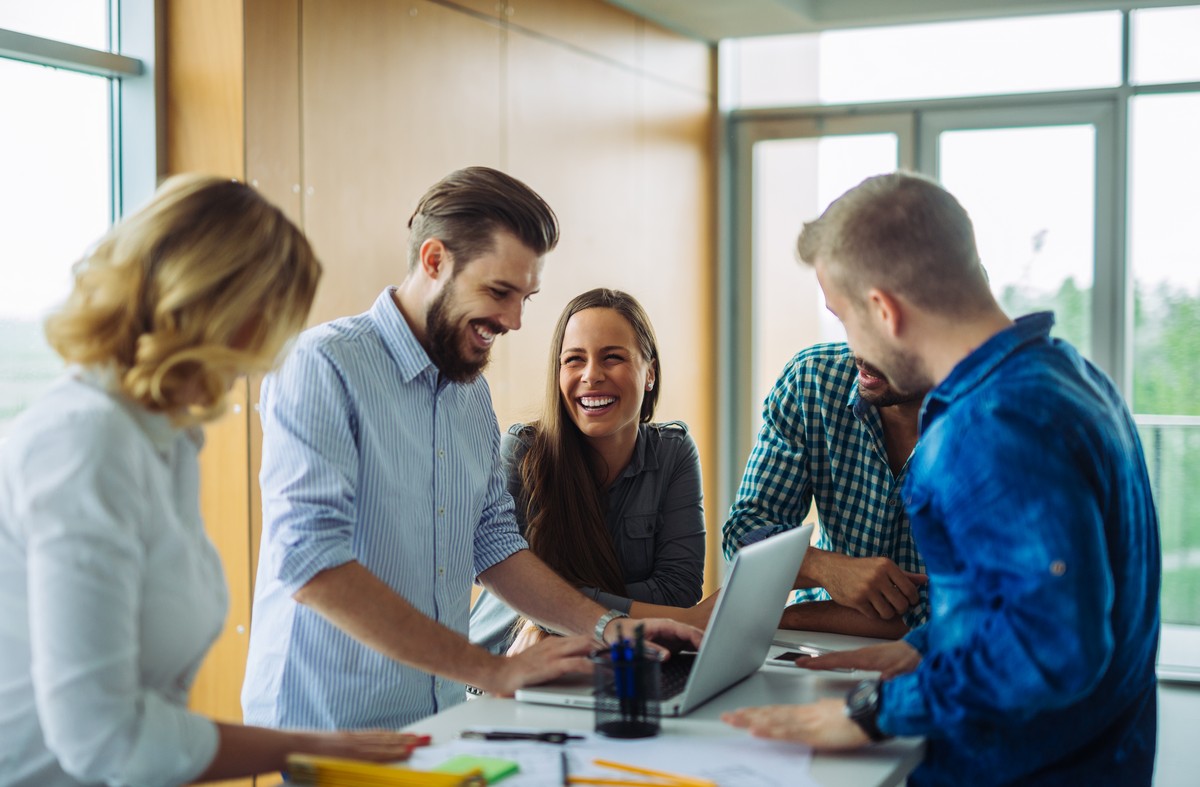 nice-to-have-feat work team laughing during a team meeting