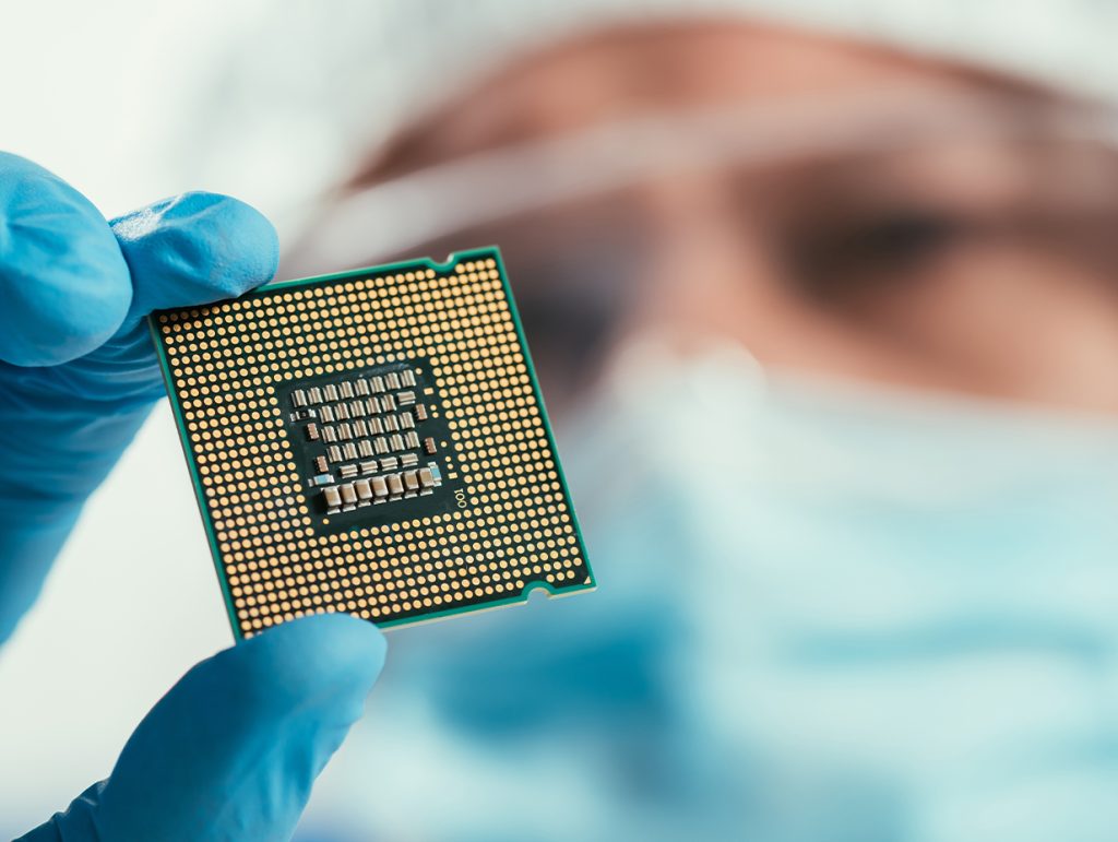 Close up of a Technician looking at a CPU in a clean room